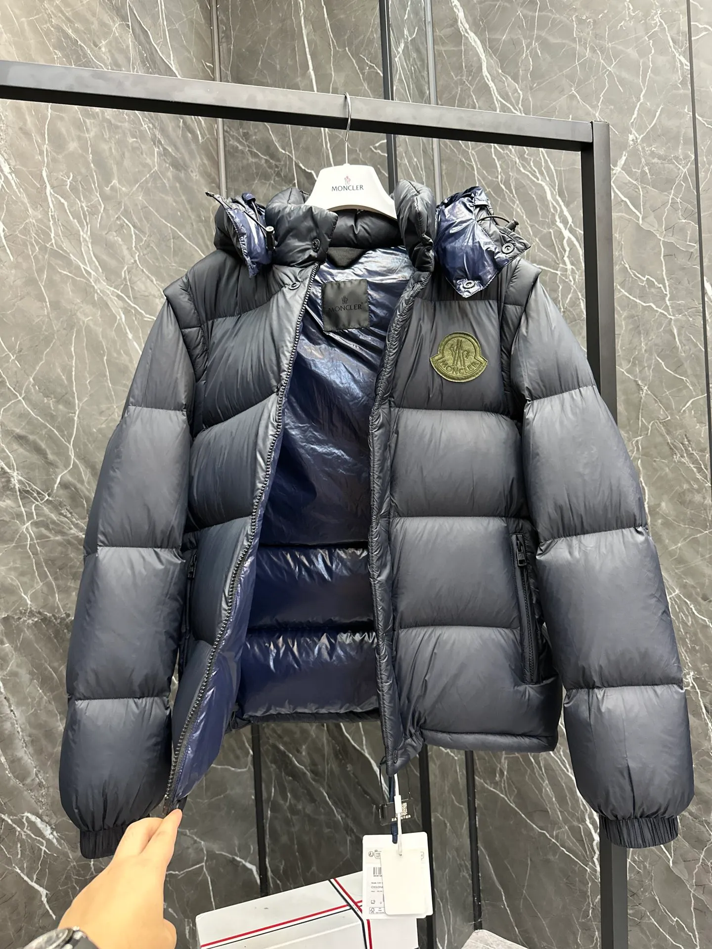 P860 Moncler Cyclone 2-in-1 down jacket. ⚠️Goose down filling, small size filling 320g➕, easy to wear in winter in one piece. Convertible/jacket/hooded vest/stand collar vest/hooded down jacket. The Cyclone down jacket comes with detachable sleeves and can be worn as a vest or jacket.  The Cyclone down jacket is a modern take on the classic silhouette of the 1980s, with a new, simple silhouette. This short down jacket is made from nylon and features easily removable sleeves, allowing you to convert the jacket into a vest. A removable hood and contrast lining complete the design. Details • Made of nylon fabric • Nylon laqué lining • Filled with down • Detachable hood and sleeves • Zipper and snap closure • Zipper pockets • Elastic cuffs • Elastic drawstring hem Size: 1-5 Dark Navy Chocolate 2 colors in Couple size.