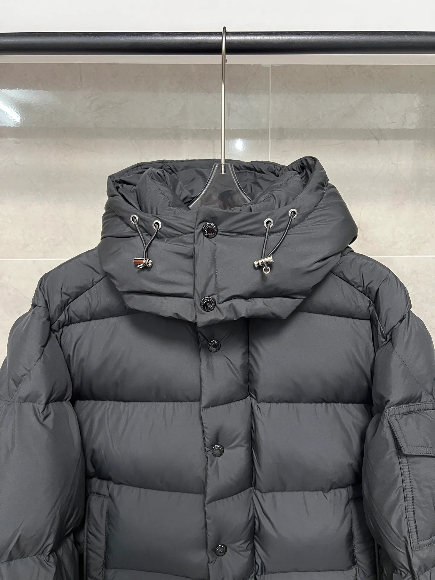 P800 Moncler matte Maya short down jacket. This short parka down jacket is made of longueSaion fabric. The garment is full of functional details to ensure warmth and care. Features removable hood, zip pockets, adjustable cuffs, and snap-zip flap fly. Logo embellished sleeves. It adds a unique touch to the overall shape and significantly improves the protective performance. Color: Black White Pink Pearl White Size: 12345