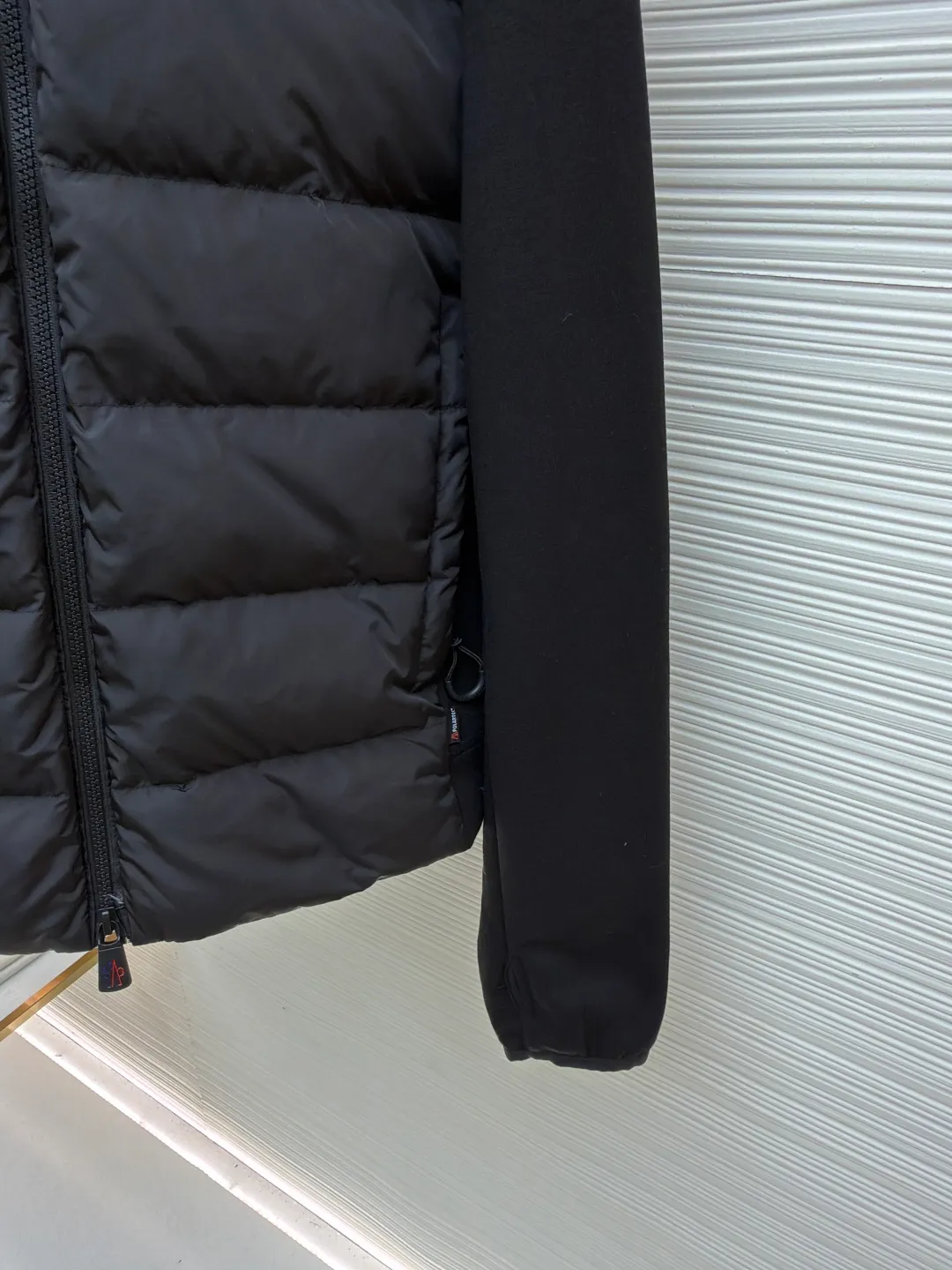 P810 Moncler logo woven splicing down jacket ●Item number: 1682129-C65 ●Material: white duck down fabric ●Technology: mechanical down filling ●Color: black ●Version: fitted version ●Weight: about 715 grams ●Size: S-M-L-XL ●Description: Customized matte lattice air shield down and 300D high-density calendered coating Use the new national standard 90 white duck down (welcome to test) Full flushing capacity Full of warmth, light and fluffy. With the dark green of the overlapping mountains as the background color, all things accumulate energy and create their own scenery in silence. The Monlcer triangle logo is embellished on the chest. The power aesthetics of the minimalist logo. The concentrated down filling in the front area creates dynamic insulation for the core heat dissipation zone of the human body. The hooded down is a moving warm flow barrier for the head and neck, forming a thermal energy circulation system with the front panel. The elastic woven sleeves provide freedom of movement with a sense of compression, forming a relaxed and warm philosophy, truly advanced. It is a mechanical down filling that allows function to become a footnote of style. Priority is given to making inner liner paper patterns to determine the down filling area and the gram weight of down per square meter according to the original three-dimensional effect, thereby calculating the filling amount of each cut piece. The computer down filling machine uses a digital weighing unit to achieve stable measurement. 3D three-dimensional quilting technology uses the programming system of the CNC quilting machine to accurately separate the down in different areas to ensure that the filling is evenly fixed after sewing. To avoid agglomeration or shifting, the template machine lines the lines. The line line process of the computer template machine shows extremely high neatness and smoothness. The craftsman accurately controls the size during the operation to ensure that each line meets the design requirements. The lines of the entire template are smooth and unified. Neat and beautiful, triple seam five-thread dense stitching process The triple structure of main seam overlocking + diagonal reinforcement + raw edge wrapping forms a three-dimensional protective net at the edge of the fabric to avoid stitch breakage. The overall wiring is straight and delicate, the fabric is comfortable and soft, and the color is consistent without color difference. It can be matched with the same style to create a fashionable look and control various occasions. Customized accessories, complete with three standards, same style for men and women!