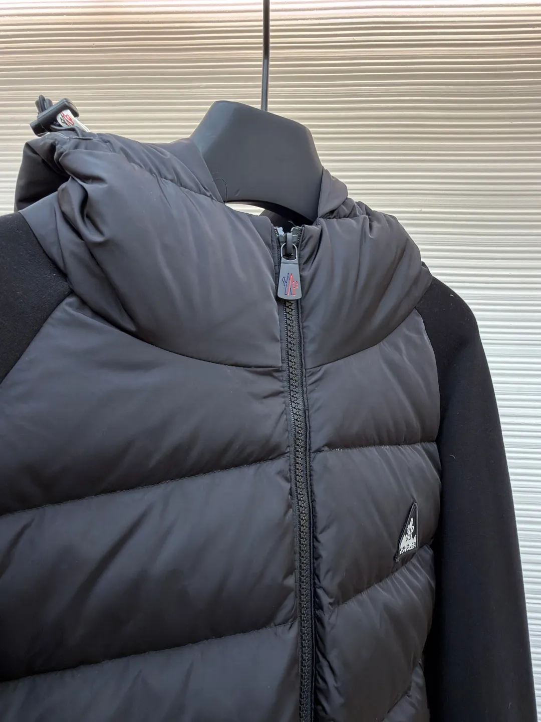 P810 Moncler logo woven splicing down jacket ●Item number: 1682129-C65 ●Material: white duck down fabric ●Technology: mechanical down filling ●Color: black ●Version: fitted version ●Weight: about 715 grams ●Size: S-M-L-XL ●Description: Customized matte lattice air shield down and 300D high-density calendered coating Use the new national standard 90 white duck down (welcome to test) Full flushing capacity Full of warmth, light and fluffy. With the dark green of the overlapping mountains as the background color, all things accumulate energy and create their own scenery in silence. The Monlcer triangle logo is embellished on the chest. The power aesthetics of the minimalist logo. The concentrated down filling in the front area creates dynamic insulation for the core heat dissipation zone of the human body. The hooded down is a moving warm flow barrier for the head and neck, forming a thermal energy circulation system with the front panel. The elastic woven sleeves provide freedom of movement with a sense of compression, forming a relaxed and warm philosophy, truly advanced. It is a mechanical down filling that allows function to become a footnote of style. Priority is given to making inner liner paper patterns to determine the down filling area and the gram weight of down per square meter according to the original three-dimensional effect, thereby calculating the filling amount of each cut piece. The computer down filling machine uses a digital weighing unit to achieve stable measurement. 3D three-dimensional quilting technology uses the programming system of the CNC quilting machine to accurately separate the down in different areas to ensure that the filling is evenly fixed after sewing. To avoid agglomeration or shifting, the template machine lines the lines. The line line process of the computer template machine shows extremely high neatness and smoothness. The craftsman accurately controls the size during the operation to ensure that each line meets the design requirements. The lines of the entire template are smooth and unified. Neat and beautiful, triple seam five-thread dense stitching process The triple structure of main seam overlocking + diagonal reinforcement + raw edge wrapping forms a three-dimensional protective net at the edge of the fabric to avoid stitch breakage. The overall wiring is straight and delicate, the fabric is comfortable and soft, and the color is consistent without color difference. It can be matched with the same style to create a fashionable look and control various occasions. Customized accessories, complete with three standards, same style for men and women!