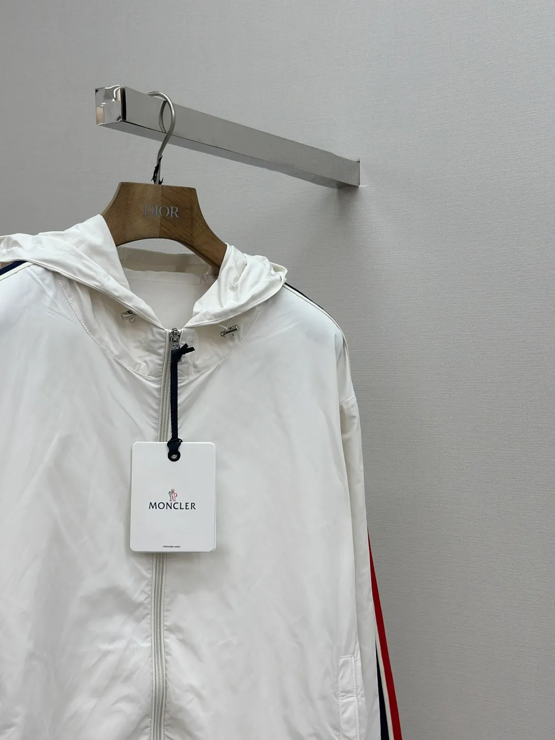 P560 MONCLER web-trimmed lightweight jacket Fabric selection: 100% polyester fiber is used to create a tough protective outer layer. It is known for its excellent tear resistance and wear resistance. It can quickly return to flatness during wearing and maintain the crisp and stylish appearance of the clothing for a long time. At the same time, it is not easy to deform after being washed for a long time.   Features: Two different colored decorative strips added to the center part of the sleeves. This design element can not only add visual highlights to clothing, making it more fashionable and unique. Craftsmanship: The webbing is precisely positioned along the cuffs to the seam of the collar and hat to ensure symmetry and overall smoothness. Before actual sewing, use very fine basting stitches for pre-fixing. This step is crucial to prevent the webbing from slipping, twisting, or wrinkling during sewing and ensuring that the final stitch is straight and perfect.  Accessories: Custom zipper puller, custom buttons with logo, custom hood drawstring elastic buckle SIZE: 1 2 3 4
