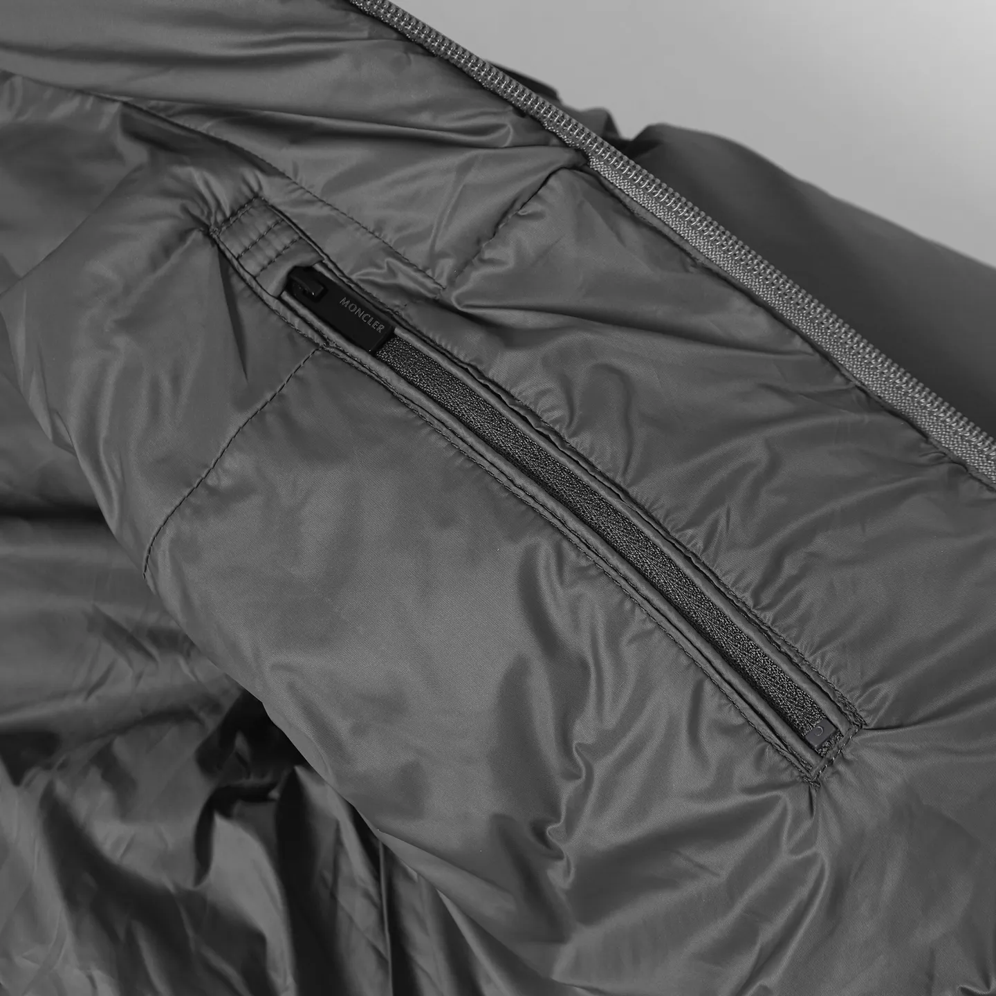 The design of the P860 Moncler Fusain short down jacket is inspired by the thrilling racing sports, echoing the three-dimensional tailoring and dynamic structure of the racing driver's uniform. Diamond quilting is used to build a thermal barrier, and the lightweight fabric is full of fluffy warmth. The silhouette is neat and not bulky, and the hooded design adds casualness. It is made of quilted nylon fabric, which has excellent warmth and protection. It is not only a textured armor to resist the cold wind when commuting, but also a fashion tool to create a minimalist and high-end feel when going out. In the cold winter, you can achieve the dual elegance of temperature and style with a piece of down. The short design features reflective zippers for a modern look. Code number: 12345 Color: black, gray
