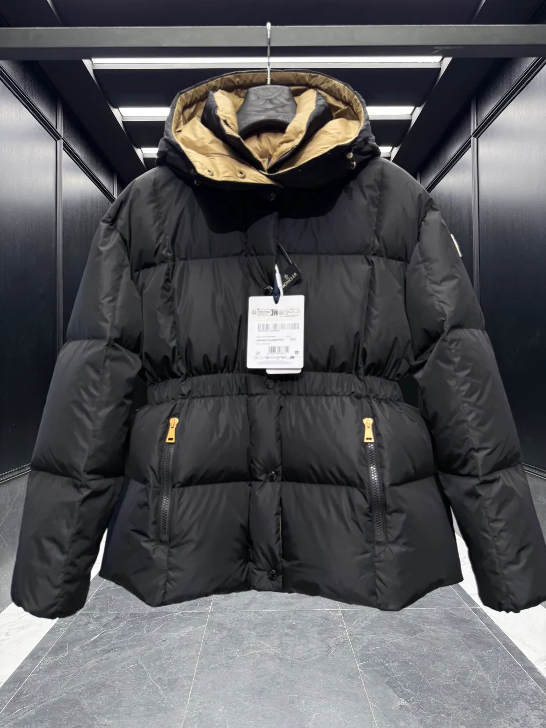 P860 ⬆️Moncler Agneux (waisted black gold) women's square quilted hooded short down jacket. Compare at will on the entire website. Arrange orders for shipment. Small sizes come out first. ⚠️Buy original and develop. Hardware pattern making countless times. All the hardware on the market is made wrong after looking at the pictures and patterns. The zipper hardware and buttons are completely two colors and two different materials. Original replacement fabric ➕Original matching hardware. I won’t go into details about the hardware. The single material will be out of stock for a few days. The barcode model number corresponds to the official website. The tag has built-in NFC inductor anti-counterfeiting. Supports multiple anti-counterfeiting verifications. 🎁The factory comes standard with a full set of counter gift box packaging. (original machine box, original shopping bag, original dust-proof grass, original hanger, original thank you card, original ribbon, upgraded original oversized magnetic gift box.) The Agneux women's short down jacket combines geometric quilting and silky texture to create a basic and exquisite piece suitable for cold weather.  Product Details: The Agneux down jacket combines protective fabrics with exquisite textures. Short fit in functional nylon with a glossy satin finish. Paired with a nipped-in waist design, it outlines a feminine silhouette.