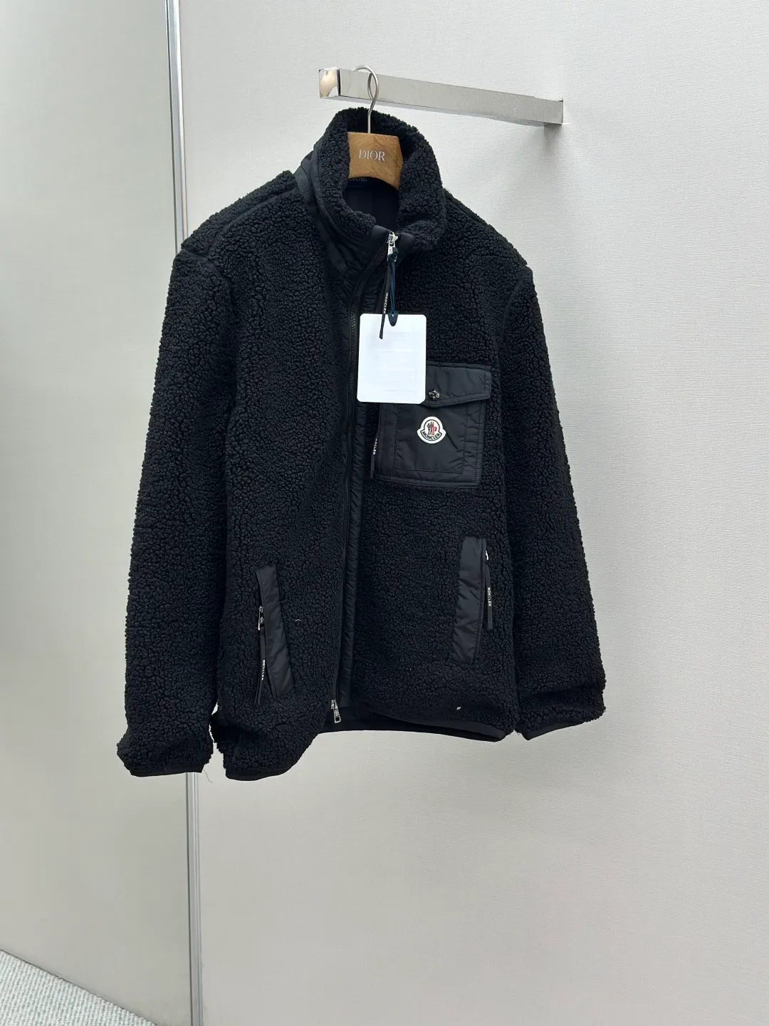 P620 MONCLER Emblem Suede Jacket Fabric Selection: Made from 100% polyester fiber, shearling fabric is woven through high-tech processing. The surface has a layer of fine, dense velvet, which feels very smooth when in contact with the skin and has good skin-friendliness. The suede surface can hold a layer of still air in place, forming a good thermal insulation layer and providing excellent warmth retention. Due to the hollow nature of the fiber, although it is warm, it does not hinder the overall lightness of the quality. Details: The neckline, front placket, side pockets, and chest patch pockets are all embellished with nylon fabrics of the same color, creating a visual sense of hierarchy. Decorated with elastic cuffs and hem, it balances practicality and beauty. Accessories: Customized zipper pendant Customized badge Customized pocket snap SIZE: S M L XL