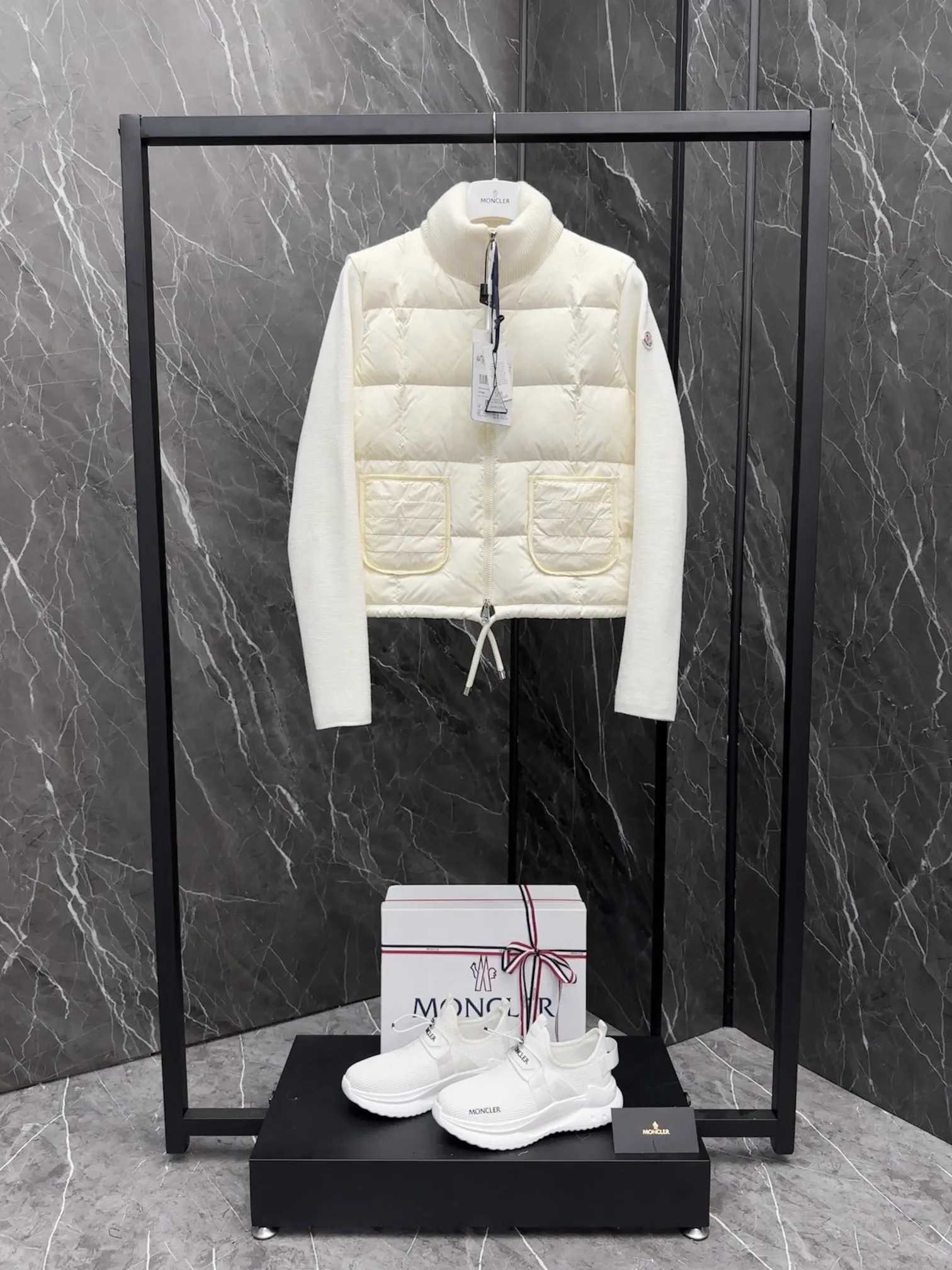 P600 New in Down ⬆️Moncler women’s padded wool zipper cardigan. This women’s wool cardigan is filled with down and can be styled in a variety of ways depending on the weather. (⚠️ Made of real wool, it will be slightly prickly when worn close to the body. It is recommended to match it with an inner layer. Fairies who are more concerned about it should not place an order.) This cardigan is made of wool and is filled with down on the front, back and collar. Lightweight knitted piece with a high collar and zip style. Details •Made from fine merino wool •Longue saison lining •Down filling at front, back and collar •Punto Milano stitching •14 stitches •Zip closure •Patch pockets •Drawstring hem Size: 1-4 Off-White Black L258031