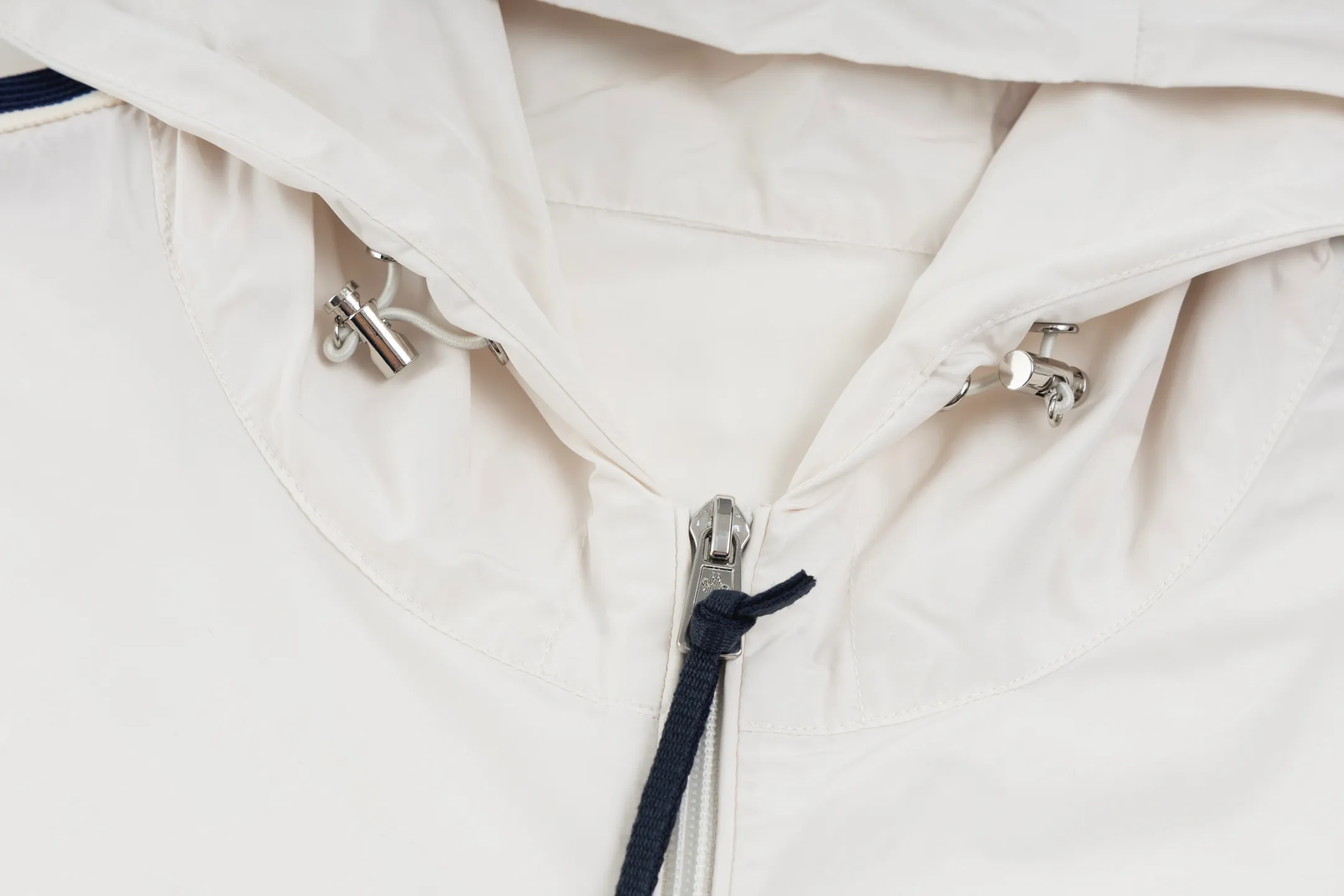 P550 Exclusive supply] Moncler Webbing Armband Lightweight Jacket (off-white) The fabric is made of 100% polyester fiber to create a tough protective outer layer. It is known for its excellent tear resistance and wear resistance. It can quickly return to flatness during wearing and maintain the crisp and stylish appearance of the clothing for a long time. At the same time, it is not easy to deform after being washed for a long time. Decorative edging in two different colors has been added to the center section of the sleeves. This design element not only adds visual highlights to the clothing, making it more fashionable and unique, the webbing is precisely positioned along the specified contours from the cuffs to the seam of the collar to ensure symmetry and overall smoothness. Before actual sewing, use very fine basting stitches for pre-fixing. This step is crucial to prevent the webbing from slipping, twisting, or wrinkling during sewing and ensuring that the final stitch is straight and perfect. Size:1/2/3/4