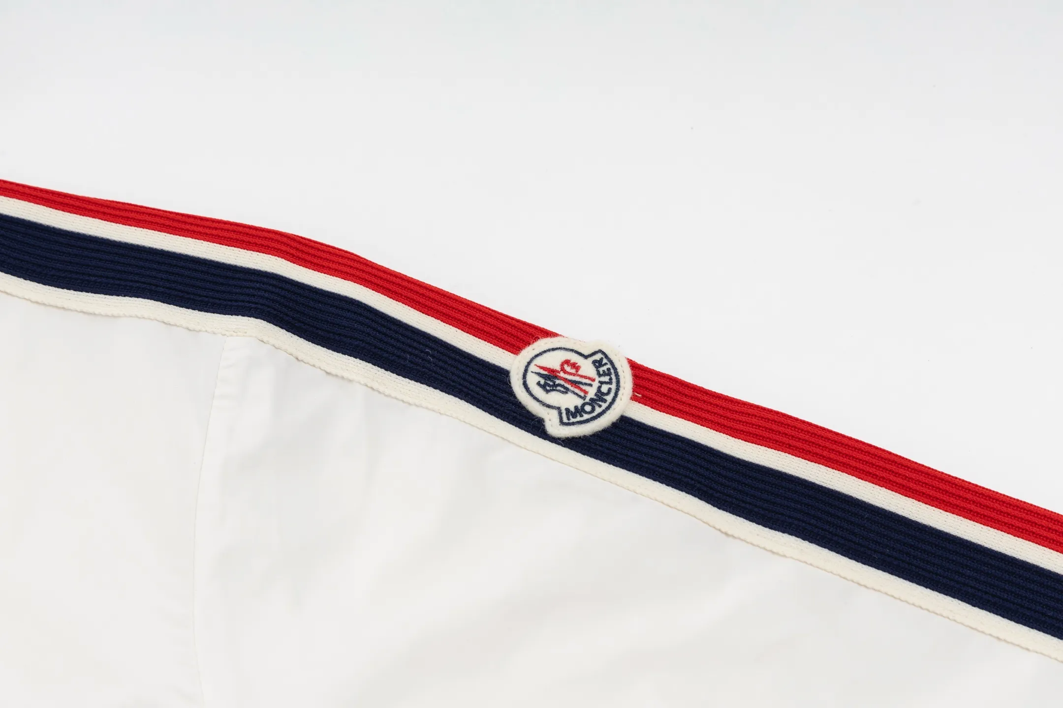 P550 Exclusive supply] Moncler Webbing Armband Lightweight Jacket (off-white) The fabric is made of 100% polyester fiber to create a tough protective outer layer. It is known for its excellent tear resistance and wear resistance. It can quickly return to flatness during wearing and maintain the crisp and stylish appearance of the clothing for a long time. At the same time, it is not easy to deform after being washed for a long time. Decorative edging in two different colors has been added to the center section of the sleeves. This design element not only adds visual highlights to the clothing, making it more fashionable and unique, the webbing is precisely positioned along the specified contours from the cuffs to the seam of the collar to ensure symmetry and overall smoothness. Before actual sewing, use very fine basting stitches for pre-fixing. This step is crucial to prevent the webbing from slipping, twisting, or wrinkling during sewing and ensuring that the final stitch is straight and perfect. Size:1/2/3/4