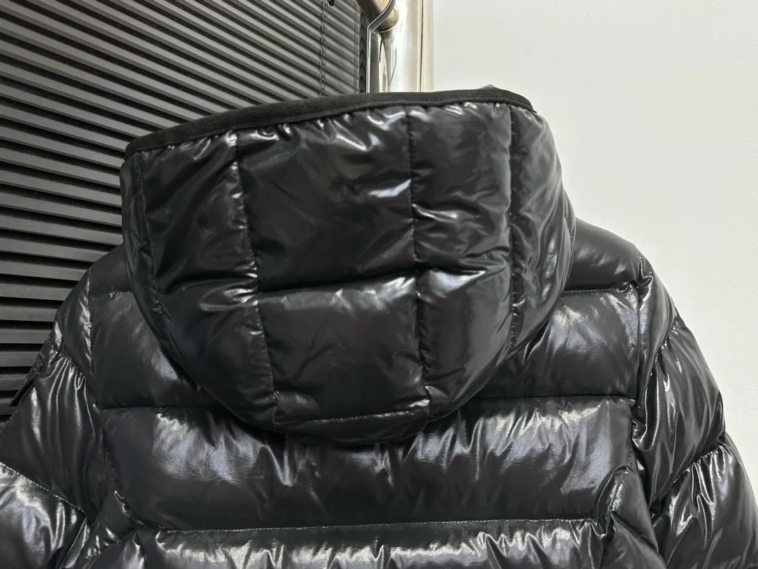 P860 [Moncler] Hooded, waisted women's short down jacket. The barante down jacket is made of glossy nylon fabric and is inspired by the 1970s. It adopts a waist design and presents an A-line silhouette, highlighting a feminine style. An adjustable hood and signature logo patch add finishing touches. Details · Made of lon laqué fabric · lon laqué lining · Filled with down · Adjustable hood · Zipper and snap closure · Suit pocket · Adjustable cuffs Size: 0/1/2/3