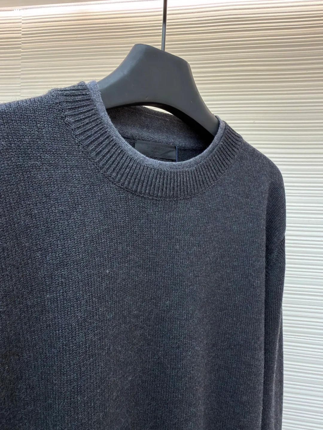 Prada round neck rib knitted cuffs and hem logo sweater ●Original version: Purchased and developed by 13114 ●Item number: 1682312-A90 ●Fabric: wool fabric ●Technology: knitted ●Color: gray ●Version: fitted version ●Weight: about 765 grams ●Size: S-M-L-XL ●Description: This Prada knitted round-neck top is woven with high-count blended wool yarn imported from Italy. It is treated with a double-ply yarn process to increase the yarn's toughness by 30%, while giving the fabric a delicate matte texture and a soft and skin-friendly touch. The main body of the garment uses a 12-needle four-flat knitting method and is designed with vertical rib texture, which not only ensures a stiff silhouette and is not easily deformed, but also allows for freedom of stretching while wearing. The neckline, cuffs and hem adopt reinforced ribbing technology, and the elastic closing is formed by precise jacquard using a computerized flat knitting machine, effectively preventing loose and curling edges. The brand metal nameplate is embedded in the side seam, which is hand-polished and then seamlessly sewn together. The splicing parts of the body are all made of concealed seam technology, making the overall lines simple and smooth. Every detail demonstrates the brand's exquisite clothing craftsmanship and strict quality control. The overall wiring is straight and delicate, the fabric is comfortable and soft, and the color is consistent without color difference. It can be matched with the same style to create a fashionable look and control various occasions. Customized accessories, complete with three standards, same style for men and women!