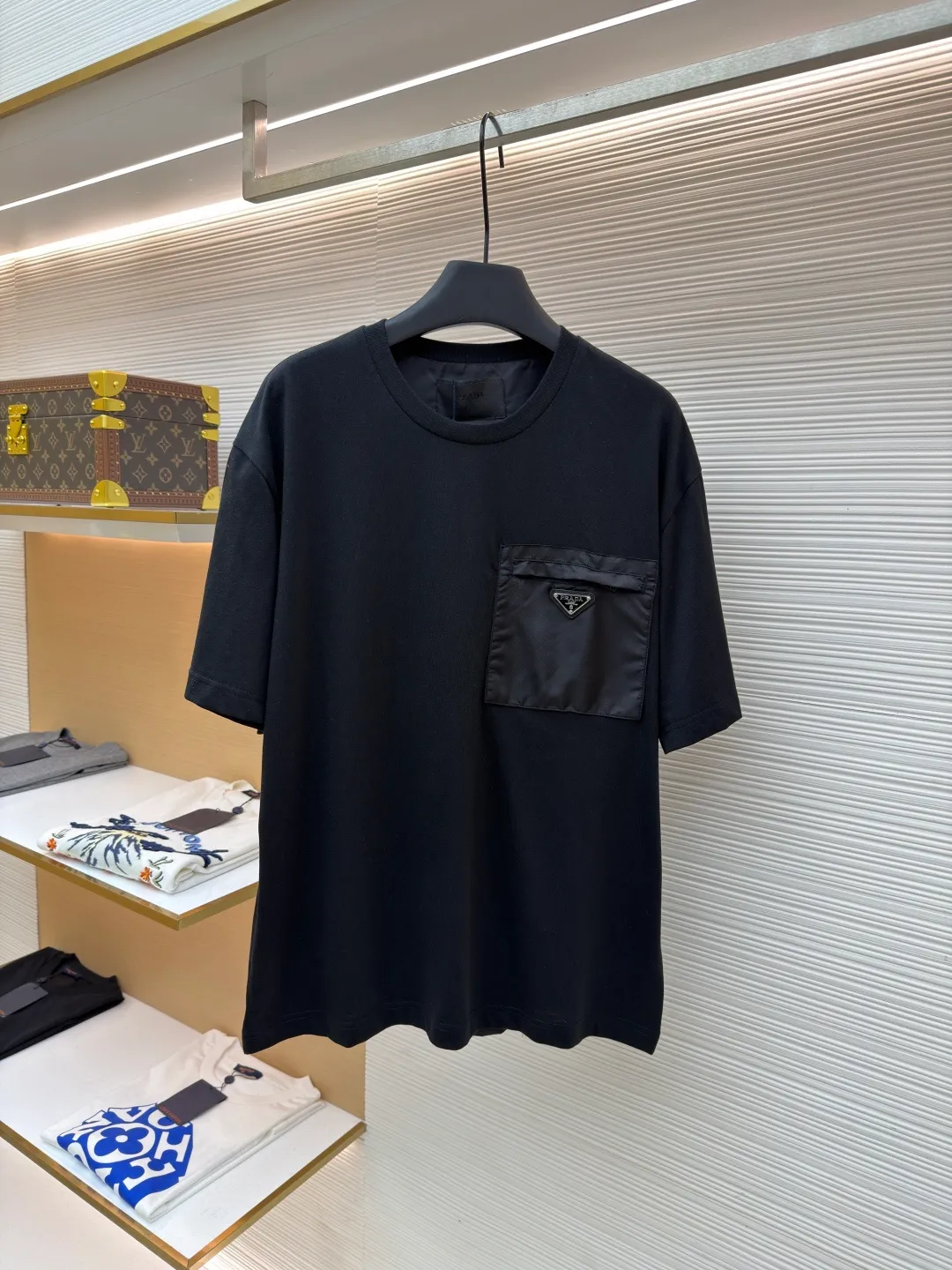 Prada Triangle Logo Pocket Short Sleeves ●Original version: Purchased and developed for 7000 ●Item number: 1682396-A05 ●Fabric: High-elastic jersey fabric ●Technology: Needle and shuttle stitching ●Color: black ●Version: Fitted version ●Weight: about 235 grams ●Size: S-M-L-XL ●Description: Customized high-elastic jersey material, delicate and soft, comfortable and close to the skin, a touch of simple white, pure and elegant. The iconic Prada triangle logo is embellished on the chest. It is integrated with Re-Nylon nylon fabric to decorate the square silhouette. Cross-disciplinary aesthetic grafting. The exquisite small pocket design highlights quality and style. It reveals a flexible and relaxed beauty. It is a picture of strolling in the city and deconstructs the attitude of the modern gentleman. The infrared positioning of the "Prada triangle mark" by an imported special machine is more precise and firm. Needle and shuttle stitching technology can make full use of the respective advantages of knitted fabrics and woven fabrics. By choosing the appropriate sewing process and stitches, it can ensure that the splicing parts are strong and beautiful. Template machine bag opening The preset template guides the position, shape and size of the bag opening. The accuracy ensures the quality of the bag opening effect. The overall wiring is straight and delicate, the fabric is comfortable and soft, and the color is consistent without color difference. It can be matched with the same style to create a fashionable look and control various occasions. Customized accessories, complete with three standards, same style for men and women!
