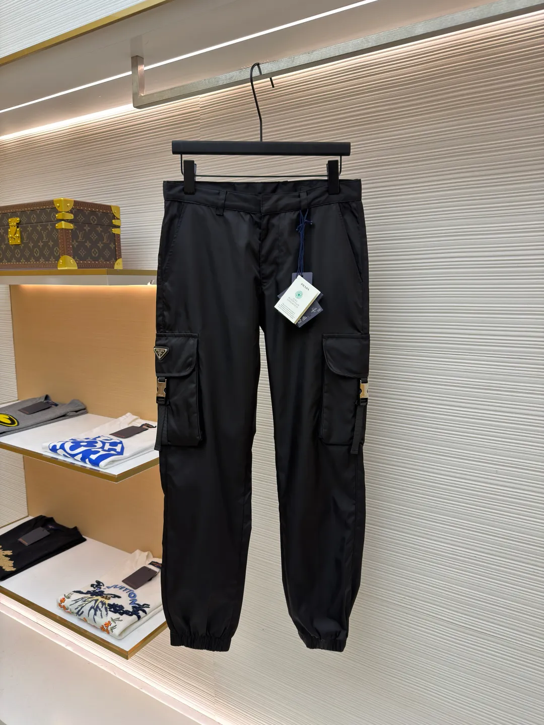 Prada iron brand triangle casual trousers ●Original version: purchased and developed by 6809 ●Item number: 1682077-B50 ●Fabric: nylon fabric ●Technology: made on positioning cutting machine ●Color: black ●Version: fitted version ●Weight: about 415 grams ●Size: 30-31-32-33-34-36 ●Description: This Prada work trousers are made of the brand's iconic regenerated nylon fabric. It has undergone a special water-repellent treatment process to make the fabric both lightweight and wear-resistant, with a delicate matte satin texture on the surface. The body of the trousers adopts three-dimensional tailoring technology and is combined with a multi-piece splicing structure to create an ergonomic trousers silhouette; the cargo pockets on both sides are reinforced with double-layer sewing technology, and the pocket openings are decorated with metal buckles and webbing. They are manually assembled and adjusted to ensure smooth opening and closing. The waistband has a built-in drawstring design. The drawstring is heat-cut and edge-sealed to prevent loosening. The rib cuffs of the trousers are made of high-elastic spandex blend material and are shaped through a shaping process to ensure long-lasting elasticity. The triangular logo on the pocket is formed using a metal die-casting process and is polished and plated to reveal a delicate luster. Every stitching follows the brand's strict stitch length standards, demonstrating the essence of high-end clothing craftsmanship. The overall wiring is straight and delicate, the fabric is comfortable and soft, and the color is consistent without color difference. It can be matched with the same style to create a fashionable look and control various occasions. Customized accessories, complete with three standards, same style for men and women!