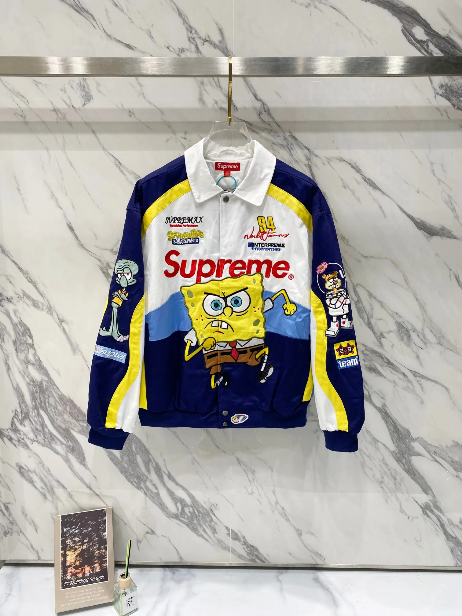 P760 Supreme SpongeBob SquarePants x JEFF HAMILTON joint model SS WEEK11 cartoon print pattern embroidered logo racing American trendy jacket, same style for men and women. A popular item in the trend circle is coming. Three-party masterpiece jackets are launched. When the street king Sup meets the childhood top SpongeBob SquarePants, when Jeff Hamilton's heavy machine embroidery hits the Beach Castle, everyone goes berserk. This jacket has become a mobile trend temple, and the wonderful chemical reaction is full instantly. Pink and black contrasting racing genes, blue, white and yellow collide to create sparks of vitality. Spongebob's angry and funny look is very personalized. Sandy and Squidward are "assist" by the side. Every pattern hides memories. This is not a simple jacket, but a work of art intertwined with trends and emotions. Wear it, walk out your own cool steps, and easily capture the attention of everyone! If you are trendy, don’t miss this co-branded jacket. Original development. Complete accessories. Exquisite workmanship. The quality is as good as ever. Color: black white. Size: S M L XL size: length 76, bust 148, shoulder width 62