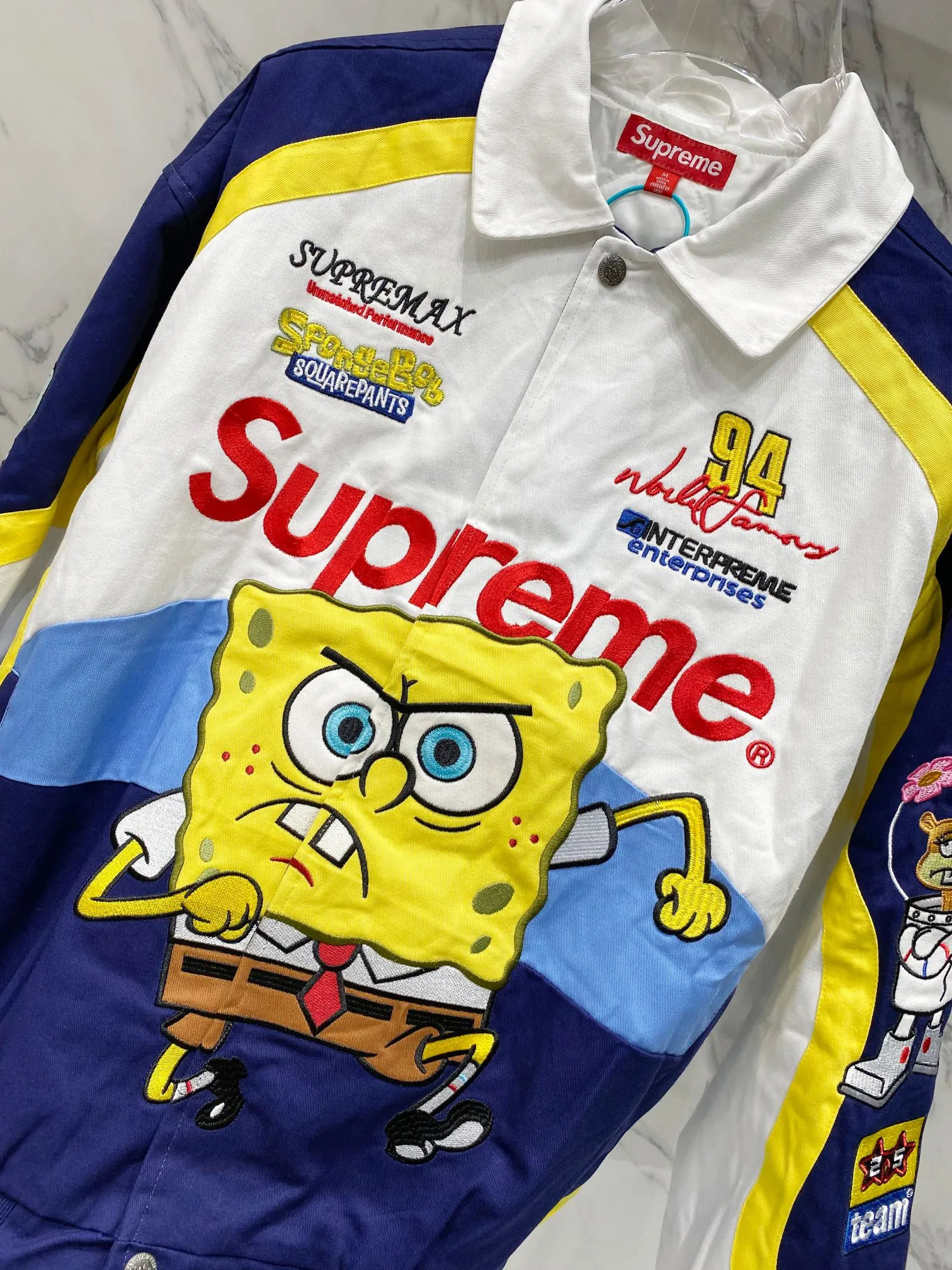 P760 Supreme SpongeBob SquarePants x JEFF HAMILTON joint model SS WEEK11 cartoon print pattern embroidered logo racing American trendy jacket, same style for men and women. A popular item in the trend circle is coming. Three-party masterpiece jackets are launched. When the street king Sup meets the childhood top SpongeBob SquarePants, when Jeff Hamilton's heavy machine embroidery hits the Beach Castle, everyone goes berserk. This jacket has become a mobile trend temple, and the wonderful chemical reaction is full instantly. Pink and black contrasting racing genes, blue, white and yellow collide to create sparks of vitality. Spongebob's angry and funny look is very personalized. Sandy and Squidward are "assist" by the side. Every pattern hides memories. This is not a simple jacket, but a work of art intertwined with trends and emotions. Wear it, walk out your own cool steps, and easily capture the attention of everyone! If you are trendy, don’t miss this co-branded jacket. Original development. Complete accessories. Exquisite workmanship. The quality is as good as ever. Color: black white. Size: S M L XL size: length 76, bust 148, shoulder width 62