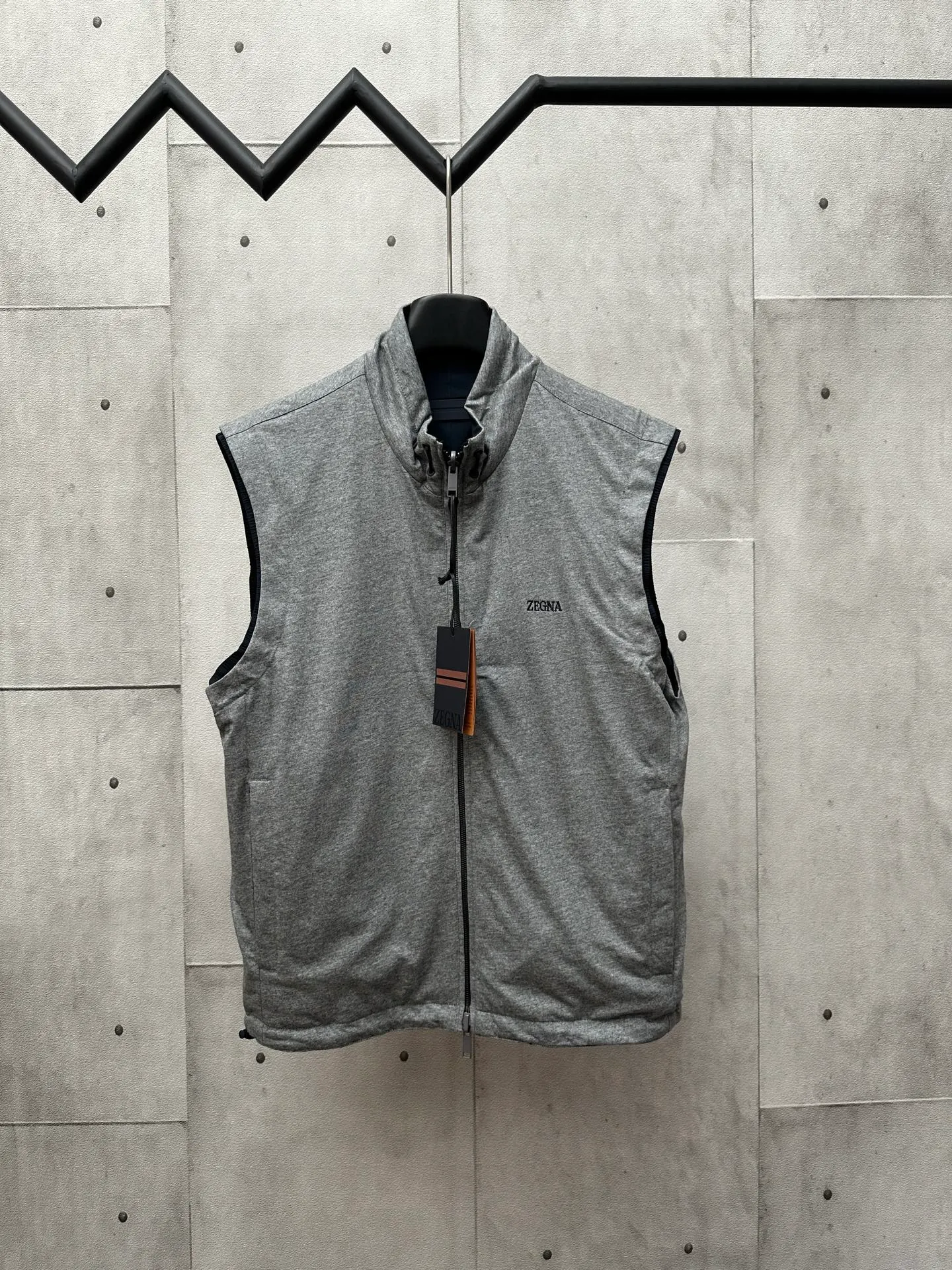 🅿️650 ZEGNA microfiber double-sided Brezza vest Fabric selection: Microfiber fabric made of 100% polyester fiber is famous for its excellent tear resistance and wear resistance. It can quickly return to flatness during wearing and maintain the crisp and stylish appearance of the clothing for a long time. At the same time, it is not easy to deform after long-term washing, ensuring dimensional stability. After being waterproofed, it can be adapted to various weather wearing needs.  Fabric on the other side: Cashmere blended jersey fabric. The diameter of cashmere fiber is only 14 microns. After blending, it eliminates the itch of pure cashmere. The central control structure locks in still air and has strong warmth retention. A small amount of nylon enhances the durability of cashmere and extends its service life.  Technology: The monochrome letter LOGO on the cashmere blended surface controls the collaborative operation of the machine head, needle bar, and bobbin through the high-precision calculation system of the computer embroidery machine. The fabric frame moves accurately in the horizontal and vertical directions to form a stitch track, and the upper and lower thread tensions are adjusted to ensure that the stitches are smooth and free of floating lines, forming a fine letter pattern with an error of ±0.1mm. Accessories: One-to-one customized neck drawstring head, One-to-one customized hem drawstring buckle, One-to-one customized zipper puller SIZE: 46 48 50 52